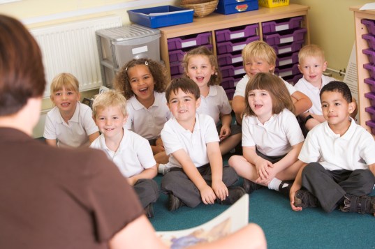 A teacher reads to schoolchildren in a primary class