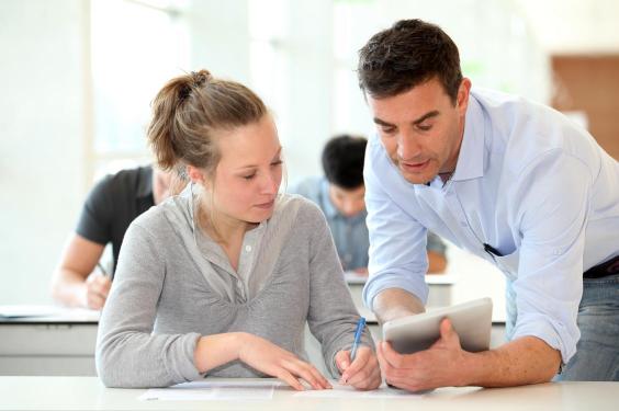 Teacher with student girl writing assignment
