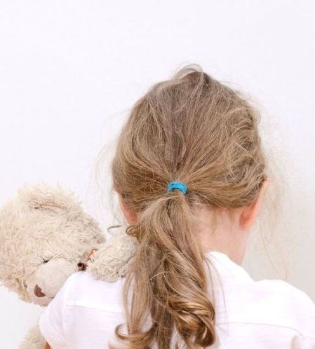 Little girl crying in the corner. Domestic violence concept.