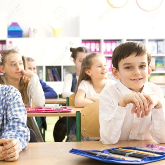 Happy kids sitting in school benchs