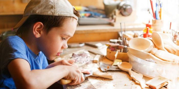 boy learning wood carving. young carpenter working in a workshop